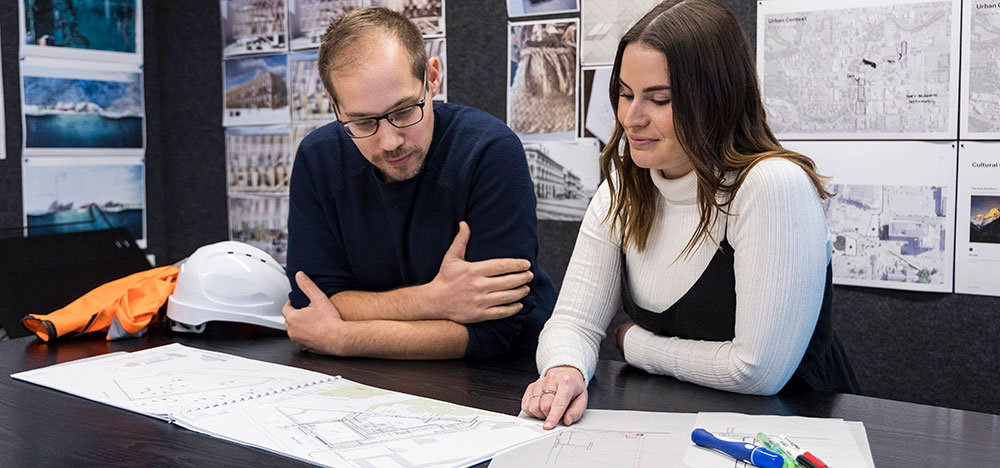 Two people looking over plans on a table